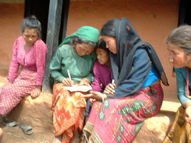 Women Action Group members working together on community records