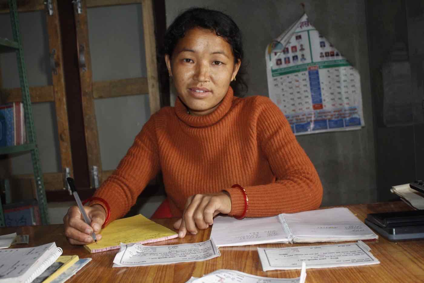 A woman keeping financial records for her community group