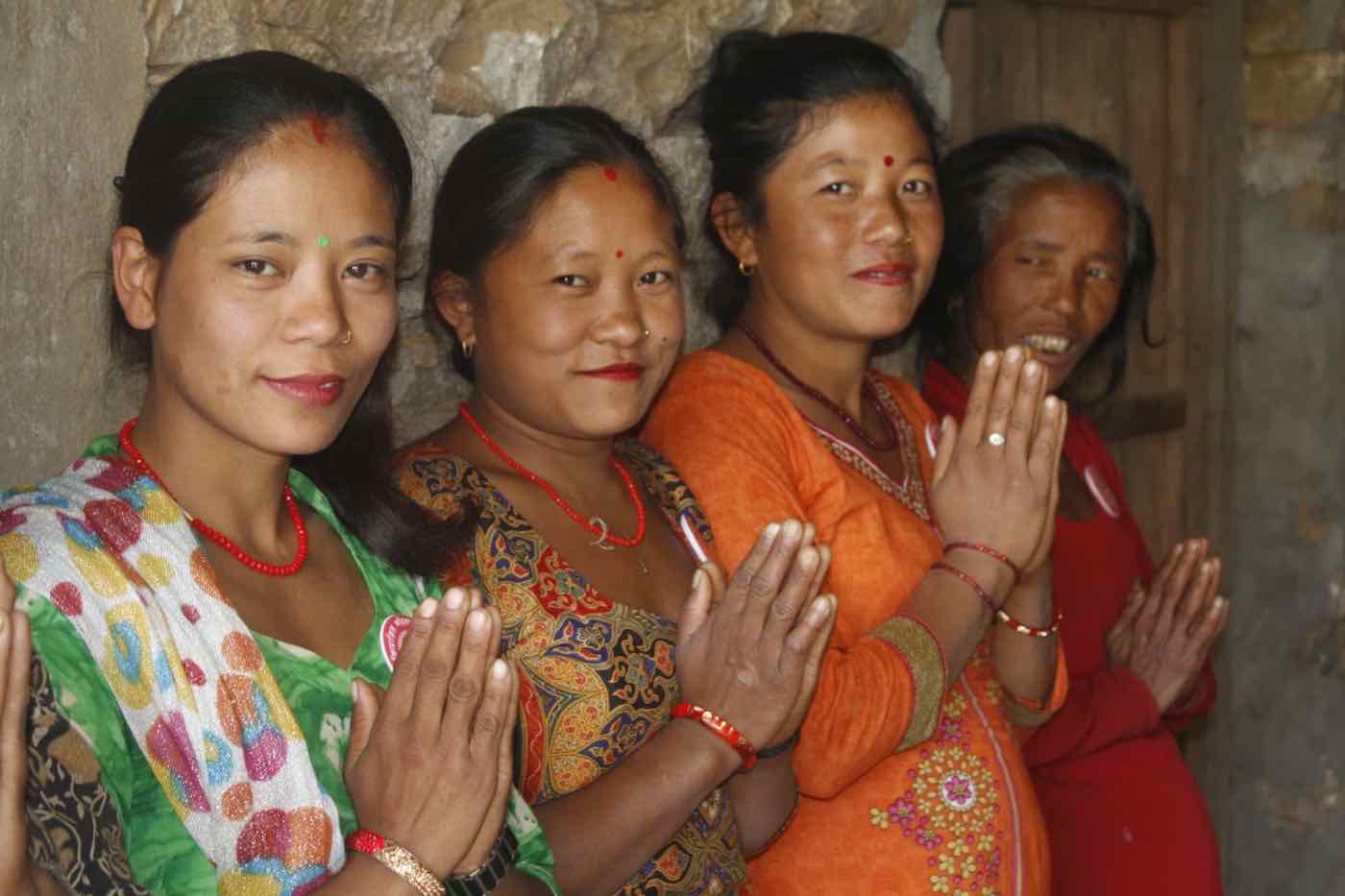 Women of a Hope Project group greeting visitors with folded hands