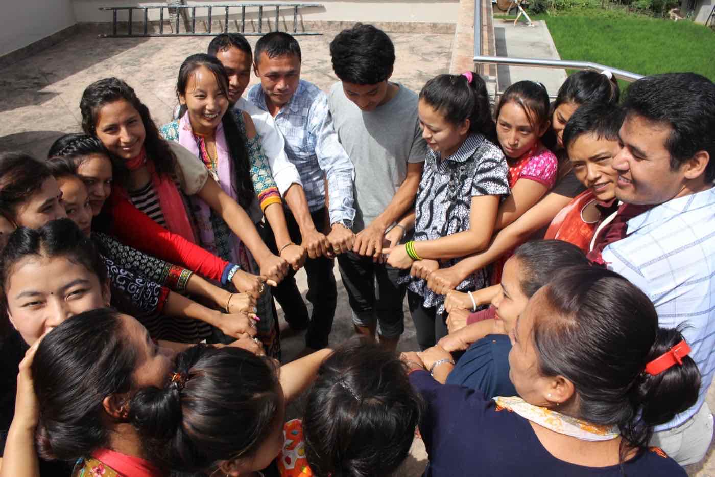 TPTC participants joining hands during a team-building exercise