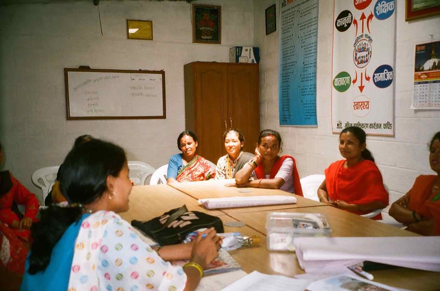 Smiling women seated around a table during a group meeting