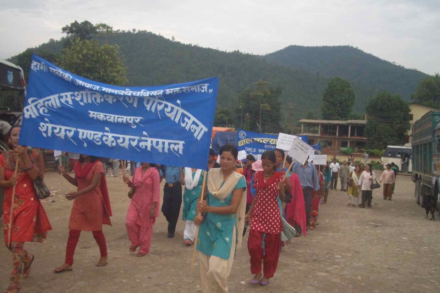 Women marching with a Share and Care Nepal banner against human trafficking in Makwanpur