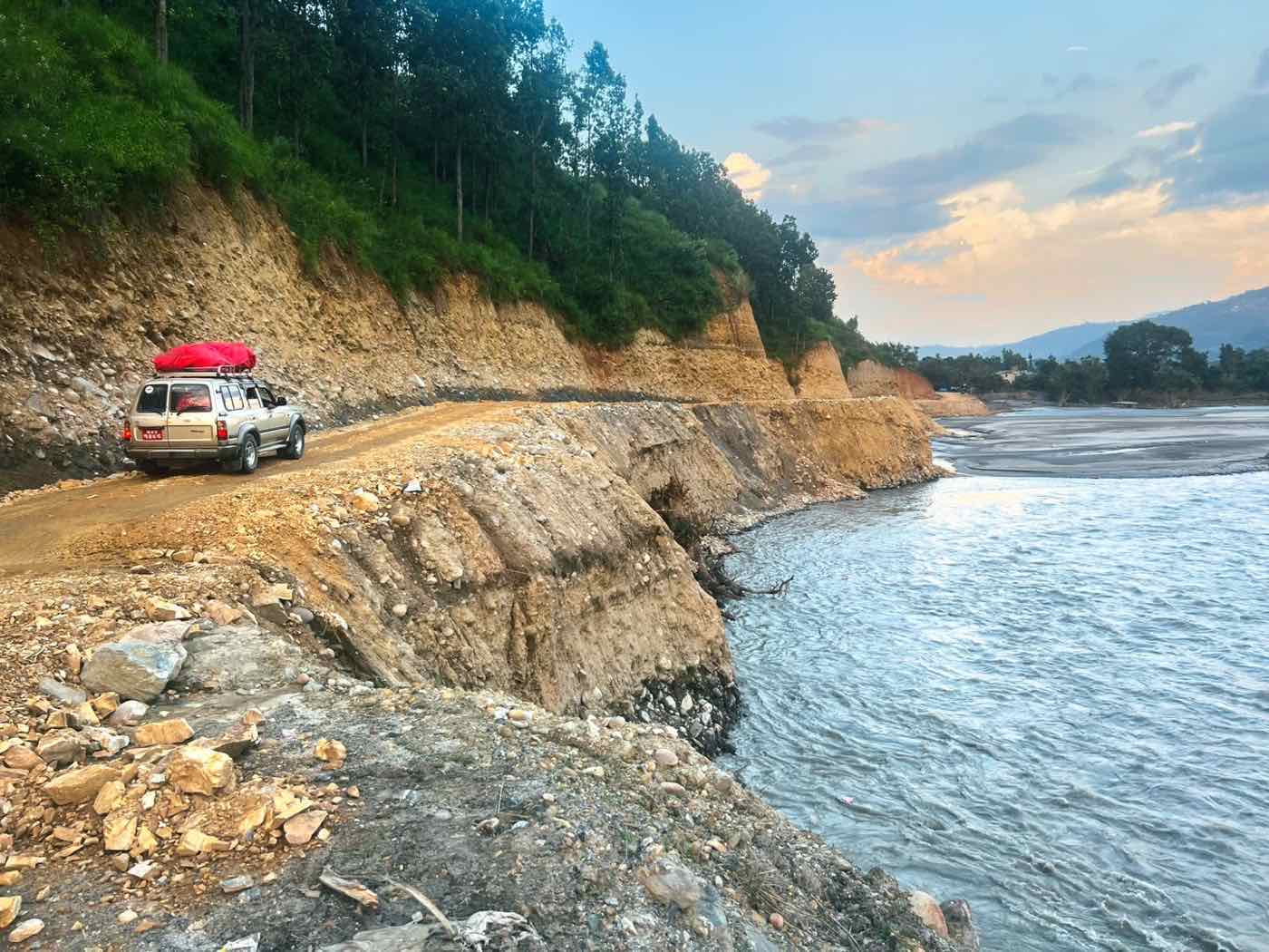 A vehicle on the narrow strip of road left beside the Bhotekoshi after the flood washed the riverbank away