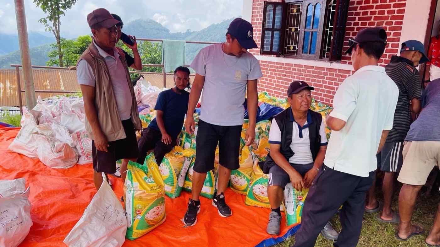 Sacks of rice and sugar sorted on tarpaulins, ready to be handed out to flood affected families