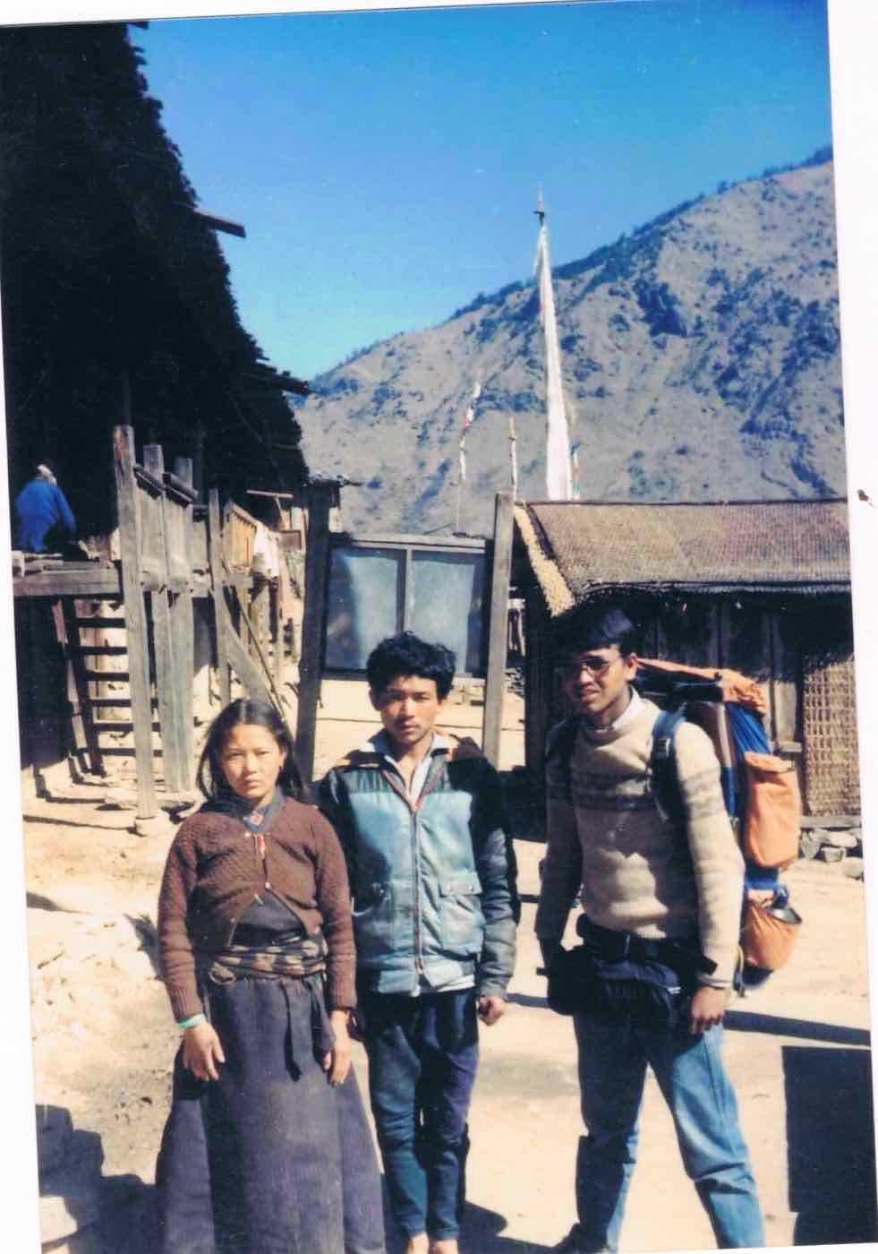 A young Ramesh Kumar Khadka, backpack loaded, with two villagers on the trek to a mountain village