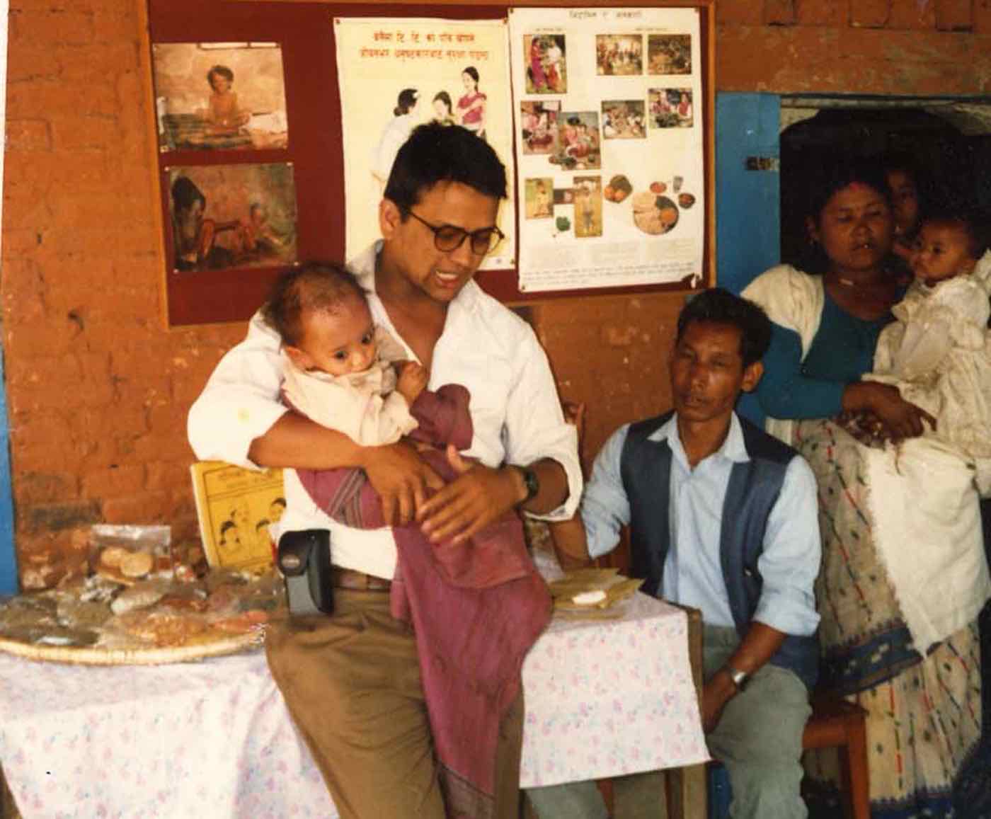 Ramesh holding a baby during a health education session at the clinic