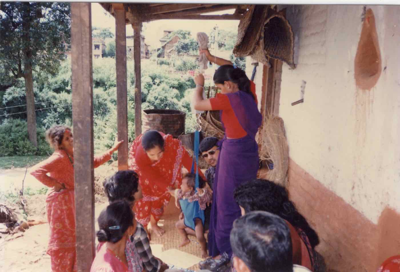 A baby being weighed on a sling scale during a community health check